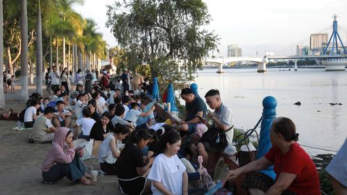 Đông đảo người dân xí chỗ từ sớm ở phía bờ đông sông Hàn để xem màn trình diễn pháo hoa đêm khai mạc. Ảnh: ĐẮC MẠNH