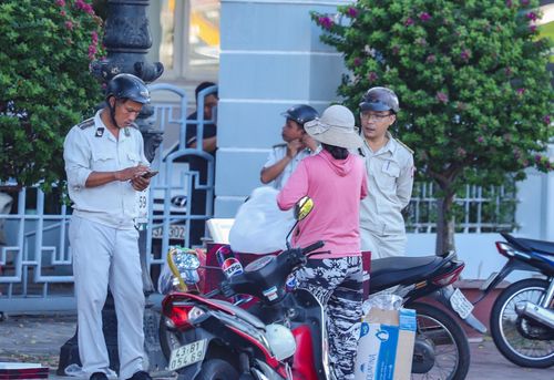 Lực lượng chức năng nhắc nhở các hộ kinh doanh. Ảnh: NGỌC PHÚ