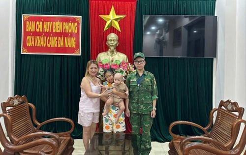 Cán bộ Ban Chỉ huy Biên phòng cửa khẩu cảng Đà Nẵng bàn giao hai cháu nhỏ bị lạc cho gia đình trong tối 30/5. Ảnh: DOÃN QUANG