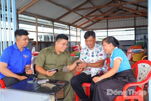 Tổ công nghệ số cộng đồng Ấp Ba hướng dẫn anh Nguyễn Văn Mạnh sử dụng VNeID, thực hiện khai báo tạm trú và các tiện ích số trên điện thoại thông minh.
