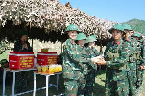 Giữa thao trường nắng gắt, những chai nước mát cùng lời động viên của cán bộ tiếp thêm tinh thần cho chiến sĩ mới vượt khó, hoàn thành tốt nội dung kiểm tra "3 tiếng nổ". Ảnh: H.P
