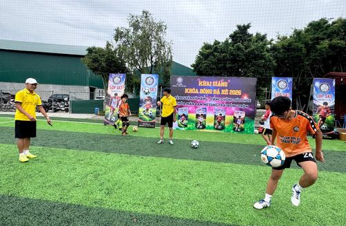 Huấn luyện viên hướng dẫn học viên kỹ thuật tâng bóng.