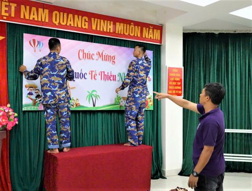 Cán bộ, chiến sĩ và đoàn viên thanh niên trên đảo Đá Tây khẩn trương trang trí sân khấu, treo cờ hoa, bóng bay để chuẩn bị cho chương trình vui tết Thiếu nhi 1/6.