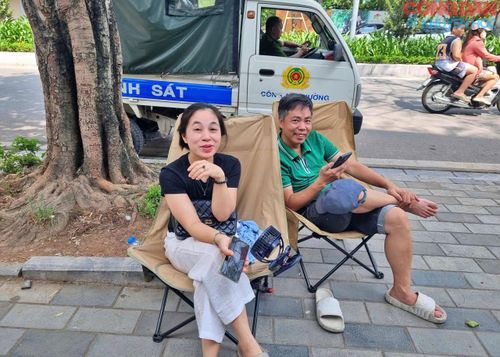 Các bậc cha mẹ ngồi đếm giờ đón con ra khỏi phòng thi.