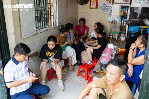 Nhiệt độ ngoài trời lên tới gần 40 độ C, các quầy trà đá xung quanh điểm thi trở thành nơi "trú nóng" của nhiều phụ huynh. Bàn ghế gần như kín chỗ khi nhiều người ngồi chờ con trong suốt thời gian làm bài.