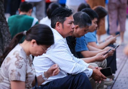 Gác lại mọi việc, các bậc phụ huynh đưa con đi thi và kiên trì chờ đợi bên ngoài điểm thi cho dù mưa to hay nắng gắt. Ảnh: Hoàng Hiếu - TTXVN