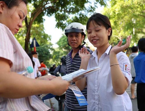 Thí sinh trao đổi về bài làm với người thân sau khi hoàn thành môn thi Ngoại ngữ tại điểm thi Trường THCS Lê Ngọc Hân. Ảnh: Thanh Tùng - TTXVN