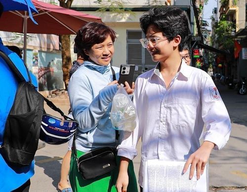 Mẹ chia sẻ cảm xúc với con trai sau khi hoàn thành tốt môn thi Ngoại ngữ kỳ thi tuyển sinh lớp 10. Ảnh: Khánh Hòa - TTXVN