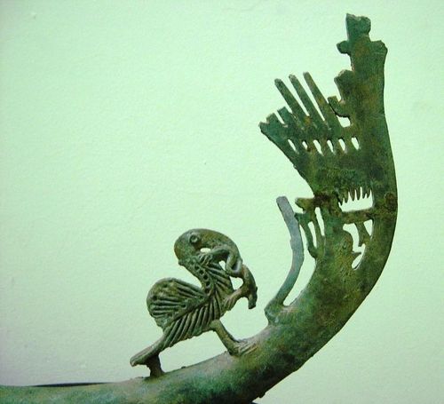 Trên một cán muôi của thầy cúng Đông Sơn có hình chim bồ nông dùng mỏ cắp một con ếch và một chim công lao từ trên trời xuống
