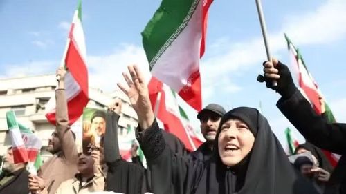 Người dân Iran tuần hành sau khi có lệnh ngừng bắn tại Tehran. (Ảnh: THX/TTXVN)
