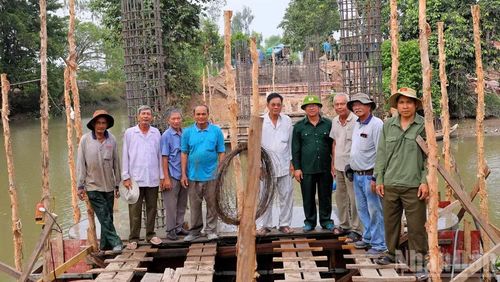 Lãnh đạo xã Châu Phú chụp ảnh lưu niệm với người dân và đội xây cầu thiện nguyện.