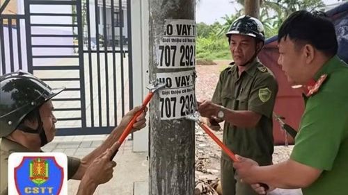 Công an và lực lượng dân quân tự vệ bóc xóa các quảng cáo dán sai nơi quy định.
