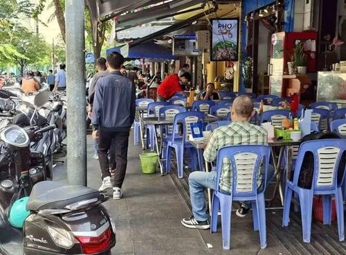 Một quán ăn khu vực trung tâm thành phố bày bàn ghế để kinh doanh trên vỉa hè. (Ảnh: MINH QUÂN)