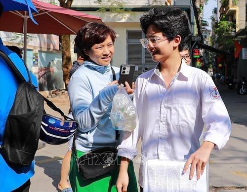 Mẹ chia sẻ cảm xúc với con trai sau khi hoàn thành tốt môn thi Ngoại ngữ kỳ thi tuyển sinh lớp 10. Ảnh: Khánh Hòa/TTXVN