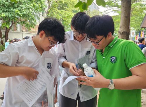 Nguyễn Chí Kiệt (áo xanh) học sinh Trường trung học cơ sở Kim Giang cùng bạn xem lại đề thi.
