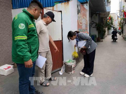 Cán bộ phường Ngô Quyền giám sát, nhắc nhở hộ dân phân loại rác sinh hoạt đúng quy định. Ảnh: Hoàng Ngọc - TTXVN