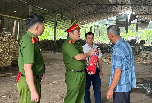 Lực lượng chức năng tuyên truyền, hướng dẫn người dân sử dụng bình chữa cháy.