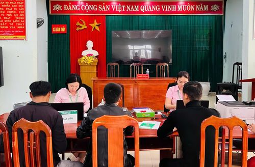Cán bộ Phòng Giao dịch Ngân hàng Chính sách xã hội Lệ Thủy hướng dẫn người dân thực hiện thủ tục vay vốn chính sách - Ảnh: M.H