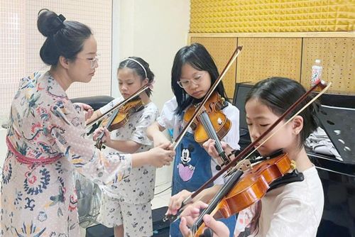 Giáo viên tại Cung Thiếu nhi Hà Nội tận tình hướng dẫn trẻ học đàn. Ảnh: Đỗ Tâm.