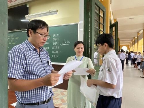 Giám thị kiểm tra thông tin thí sinh trước khi vào phòng thi. Ảnh: Đ.Xá.