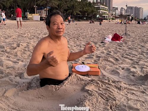  Ông Phạm Thanh, 67 tuổi, từ hơn 4 năm nay đều đặn ra biển vùi mình. "Chôn cát khoảng 30 phút, tôi thấy người nhẹ hơn, đỡ đau khớp hẳn", ông Sơn chia sẻ. 