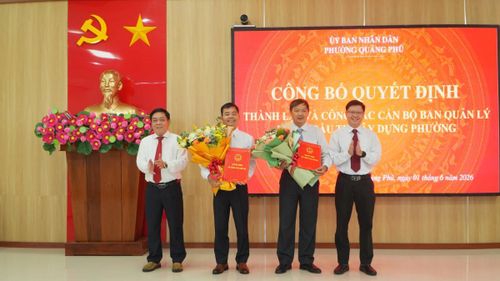 Lãnh đạo phường Quảng Phú trao quyết định và tặng hoa chúc mừng lãnh đạo Ban Quản lý dự án đầu tư xây dựng phường.