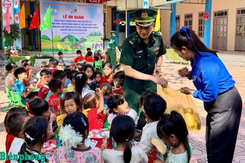 Cán bộ Đồn Biên phòng Nậm Nhừ và đại diện Đoàn Thanh niên xã Nà Hỳ chăm lo bữa ăn cho các em học sinh. Ảnh: Mùa Tùng
