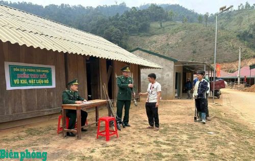 Nhân dân giao nộp vũ khí, vật liệu nổ cho cán bộ Đồn Biên phòng Tam Chung. Ảnh: Đình Duyên