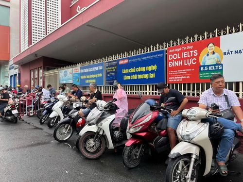 Nhiều phụ huynh vẫn kiên nhẫn đứng chờ con dù trời mưa lớn.