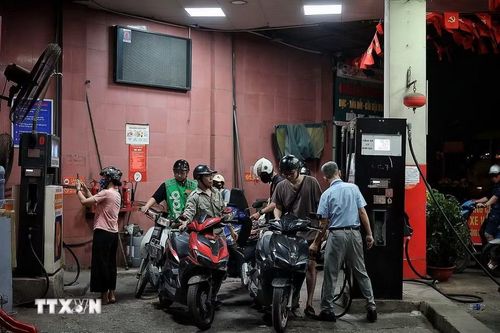 Người dân đổ đầy bình xăng RON95 trước ngày chuyển đổi sang E10 (ảnh chụp đêm 31/5). (Ảnh: Phạm Tuấn Anh/TTXVN)