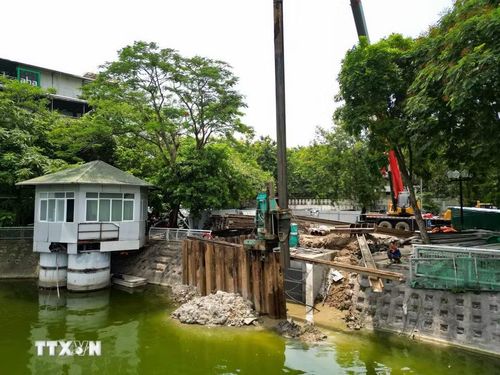 Máy cẩu và máy ép cừ được huy động đồng bộ tại công trường trạm bơm hồ Xã Đàn, phục vụ thi công các hạng mục kết cấu ngầm quan trọng của dự án. (Ảnh: Lê Đông/TTXVN)
