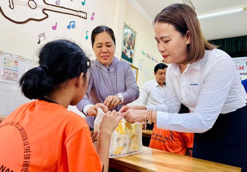 Phó Chủ tịch Ủy ban MTTQ Việt Nam thành phố Trần Thị Mẫn (bên phải) trao quà cho trẻ em có hoàn cảnh đặc biệt. Ảnh: ĐĂNG NGUYÊN