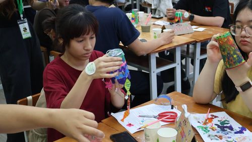 Người tham dự tự tay trang trí những chiếc cốc nhựa cũ để tạo nên các mẫu chuông gió độc đáo . (Ảnh: BTC)