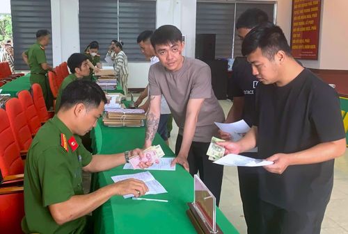  Cán bộ, chiến sĩ Trại giam Đắk Trung trao tiền hỗ trợ tàu xe và chế độ cho các phạm nhân được đặc xá. 