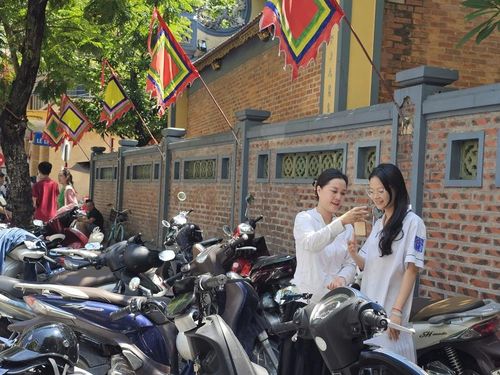 Một thí sinh gọi ngay cho người thân báo tin làm bài tốt tại điểm thi trường THPT Ngô Quyền. Ảnh: Tuệ Nhi