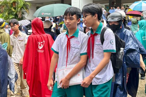  Các thí sinh vui vẻ ra về sau môn thi cuối cùng trong cơn mưa vừa tạnh tại điểm thi Trường THPT Nguyễn Hữu Thọ, phường Xóm Chiếu (TPHCM) ẢNH: HOÀNG HÙNG 