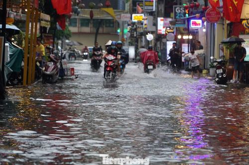 Nhiều phương tiện di chuyển chậm qua đoạn ngập sâu 30-40cm trên phố đi bộ Bùi Viện sau cơn mưa lớn.