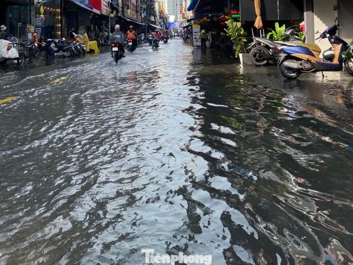 Ghi nhận tại hiện trường cho thấy nước ngập kéo dài hơn 100m trên tuyến phố “Tây” này. Nhiều người phải xắn quần, dắt xe lội qua đoạn phố bị ngập, trong khi các phương tiện lưu thông chậm chạp.