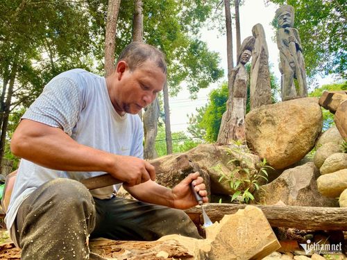 Nghệ nhân Ưu tú A Gông đang miệt mài gìn giữ nghề tạc tượng gỗ dân gian truyền thống của người Mơ Nâm. Ảnh: Ngọc Chí