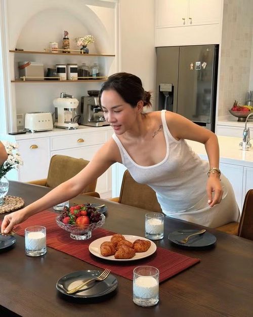 Phía sau đảo bếp là hệ tủ lạnh cỡ lớn màu ghi đậm cùng các mảng tường sáng màu được xử lý tối giản, hạn chế tối đa các chi tiết trang trí rườm rà. Cách bố trí này tạo cảm giác gọn gàng, ngăn nắp và giúp ánh nhìn tập trung vào những hoạt động diễn ra trong căn bếp thay vì đồ nội thất