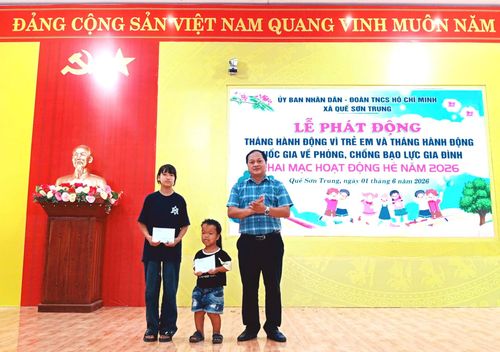 Ông Nguyễn Phước Sơn, Bí thư Đảng ủy, Chủ tịch HĐND xã Quế Sơn Trung trao quà cho trẻ em có hoàn cảnh khó khăn. Ảnh: DUY THÁI