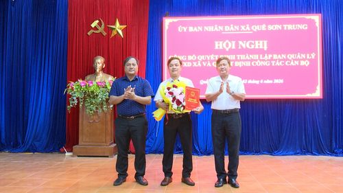 Lãnh đạo xã Quế Sơn Trung trao quyết định và tặng hoa chúc mừng lãnh đạo Ban Quản lý dự án đầu tư xây dựng xã. Ảnh: Duy Thái