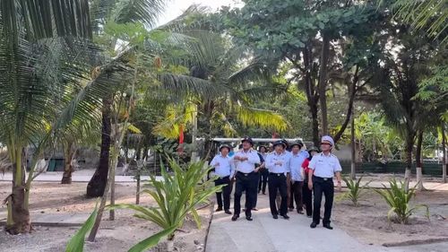 Các đại biểu đoàn công tác số 17 tham quan vườn dừa trên đảo. Ảnh: Mỹ Hà