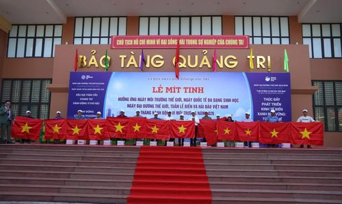 Ban Tổ chức tặng quà và cờ Tổ quốc cho các ngư dân - Ảnh: Thùy Trang