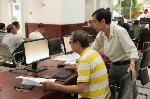 Người dân được cán bộ hướng dẫn sử dụng các dịch vụ số làm thủ tục hành chính. Ảnh: Thạc Hiếu