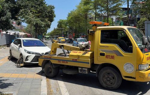 Lực lượng chức năng phường Nghĩa Đô xử lý tình trạng dừng đỗ phương tiện sai quy định. Ảnh: Vân Nhi