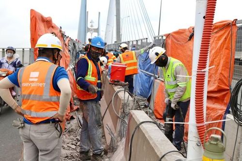 Nhiều công nhân sử dụng máy móc chuyên dụng để tiến hành việc sửa chữa cầu Phú Mỹ.