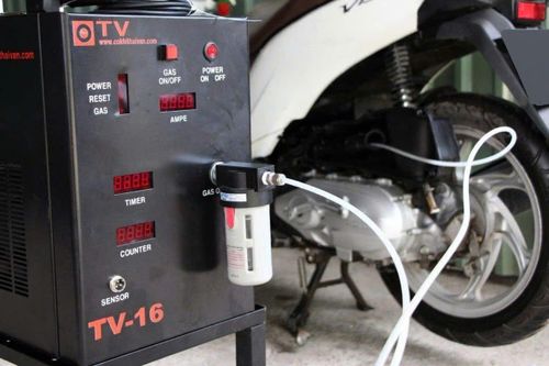 Một chiếc xe máy đang được vệ sinh buồng đốt bằng thiết bị chuyên dụng.