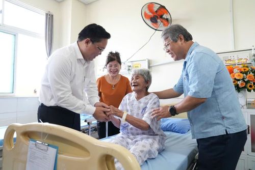 Chủ tịch Ủy ban MTTQ Việt Nam thành phố Lê Trí Thanh (bìa trái) và lãnh đạo xã Núi Thành thăm, động viên cụ Huỳnh Thị Hoa (SN 1936, trú xã Núi Thành) đang điều trị tại Bệnh viện Việt - Hàn Đà Nẵng. Ảnh: HỒ QUÂN