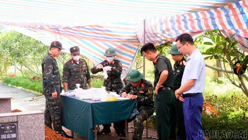 Lực lượng chức năng thực hiện lấy mẫu phục vụ công tác giám định ADN tại Nghĩa trang Liệt sĩ Văn Yên.